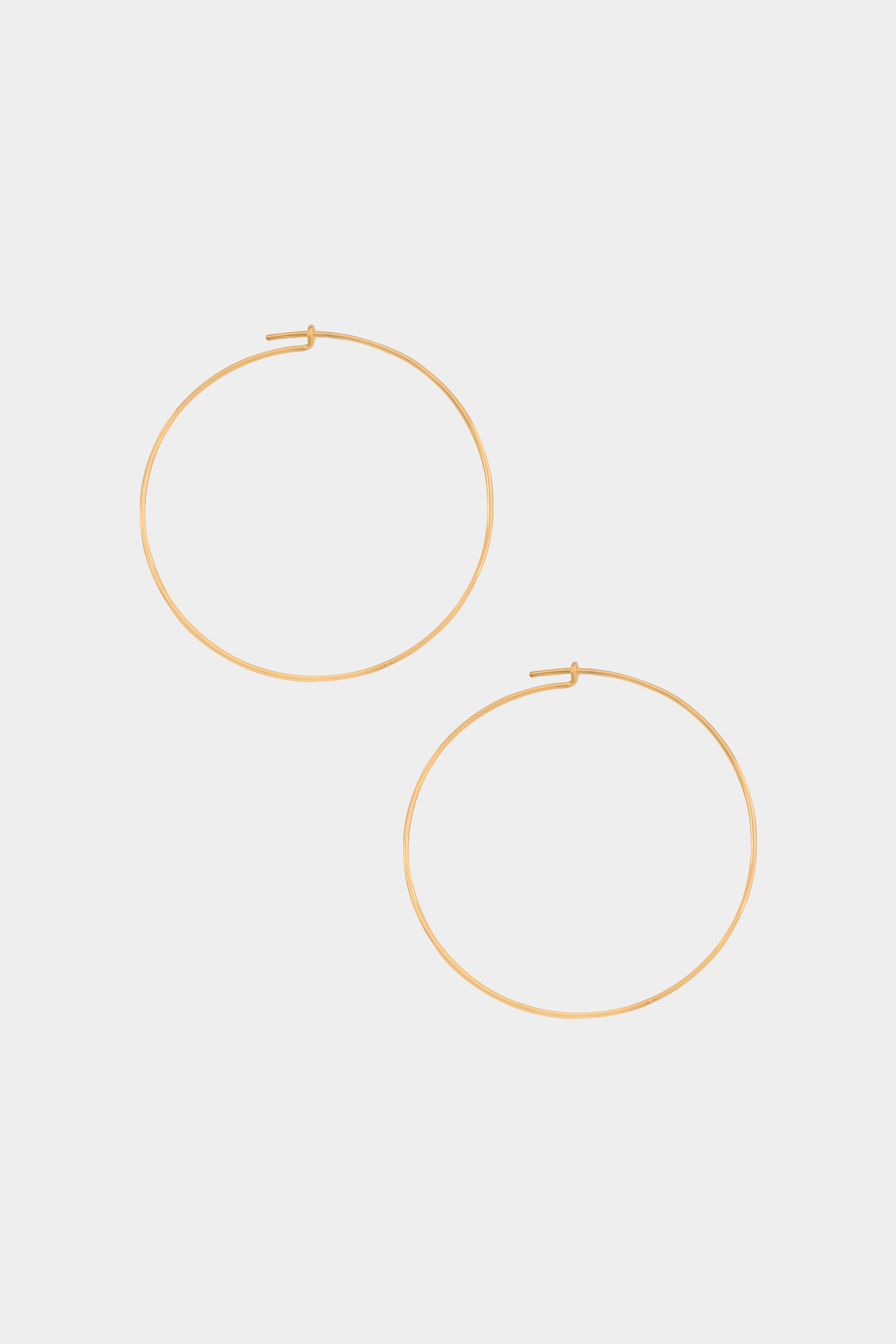 Gold hoop earrings on a light gray background