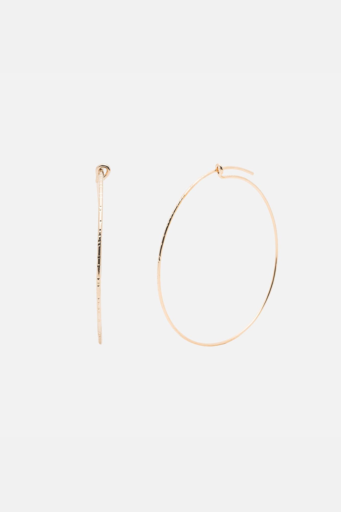 Gold hoop earring and barrette on a white background